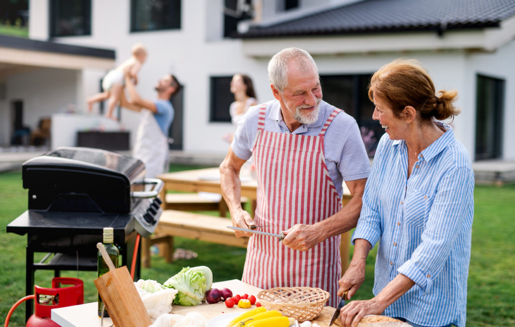 front view senior couple with family outdoors garden barbecue grilling  x