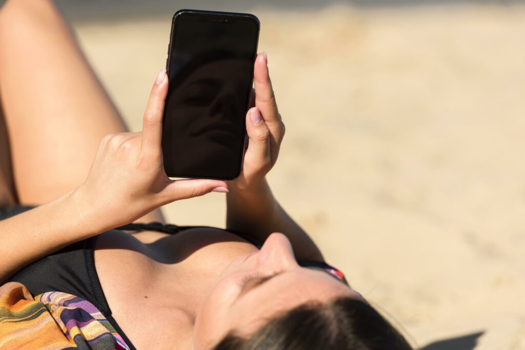 woman beach holding smartphone x