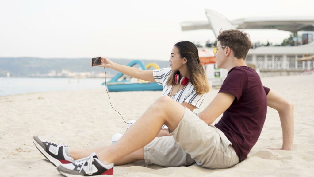 teenagers taking selfie together beach x