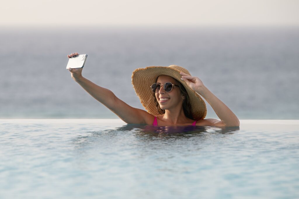 young woman taking selfie with her smartphone vacation x