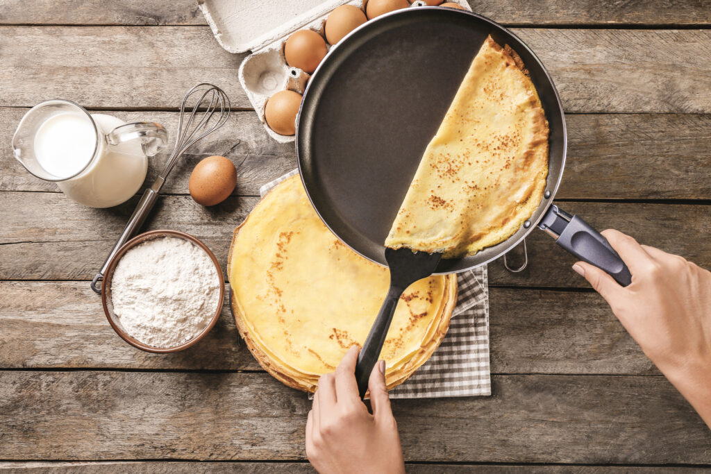 woman making thin pancakes frying pan kitchen x